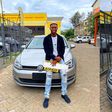 Kenyan TikTok sensation, dancer and digital content creator Only Lit Boy posing with his first car - a sleek silver-grey Volkswagen Golf TSI