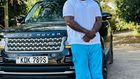 Khaligraph Jones posing with a Range Rover