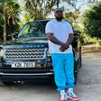 Khaligraph Jones posing with a Range Rover