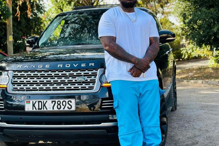 Khaligraph Jones posing with a Range Rover