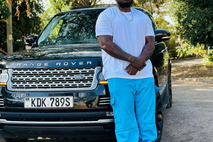 Khaligraph Jones posing with a Range Rover