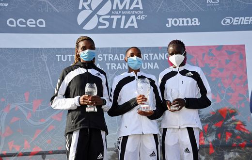 The 2021 Ostia Half Marathon women's race podium finishers Joyce Chepkemoi Tele, Betty Chepkemoi Kibet and Gloria Kite during the award ceremony