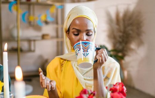 Woman in yllow hijab eating and drinking during Ramdhan [Image Credit: RDNE Stock Project]