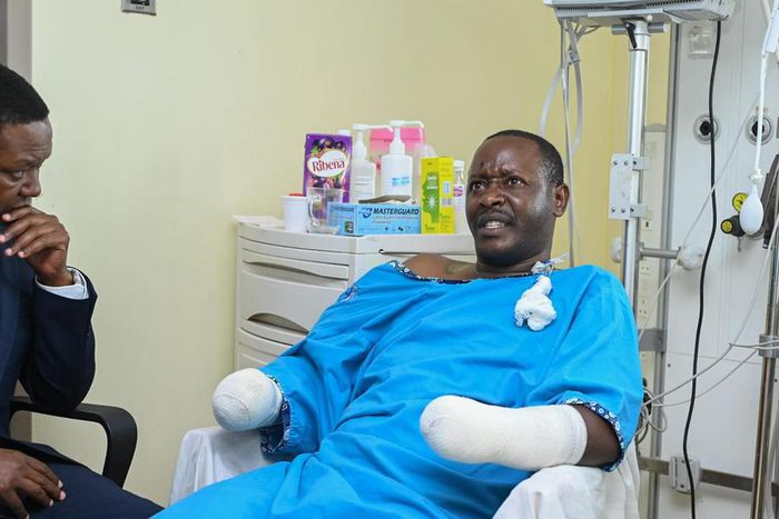 Tourism CS Alfred Mutua at Nairobi West hospital when he visited police officer David Karuri Maina who lost both arms after a teargas canister exploded during the anti-finance bill protests