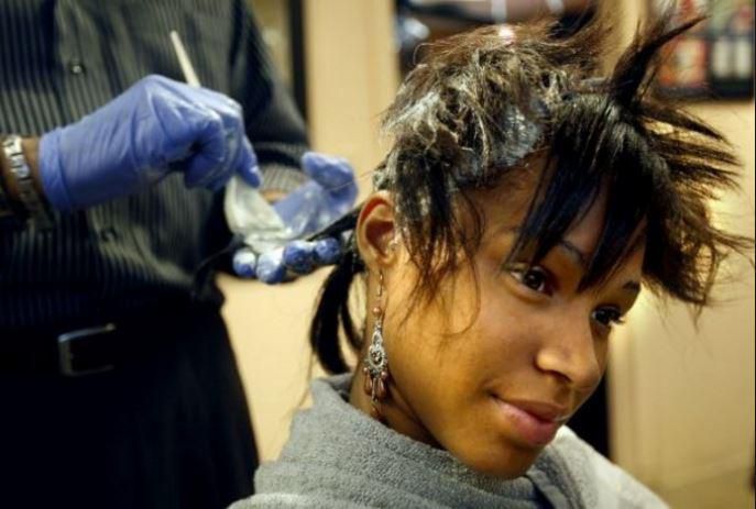 A lady getting her hair relaxed (Courtesy)