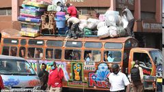 Bus attendants help fasten wares to the top of a matatu at the Machakos Country Bus Station [Photo: Steve MulwawaKi7]