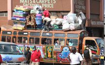 Bus attendants help fasten wares to the top of a matatu at the Machakos Country Bus Station [Photo: Steve MulwawaKi7]