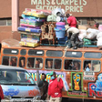 Bus attendants help fasten wares to the top of a matatu at the Machakos Country Bus Station [Photo: Steve MulwawaKi7]