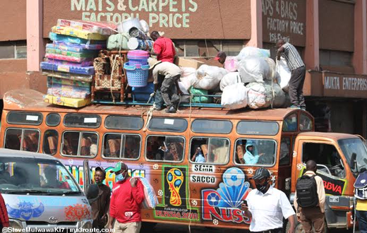 Bus attendants help fasten wares to the top of a matatu at the Machakos Country Bus Station [Photo: Steve MulwawaKi7]