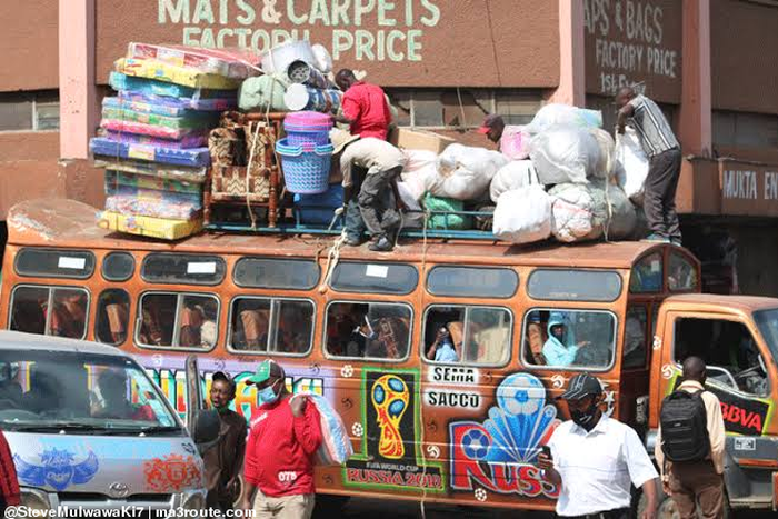 Bus attendants help fasten wares to the top of a matatu at the Machakos Country Bus Station [Photo: Steve MulwawaKi7]