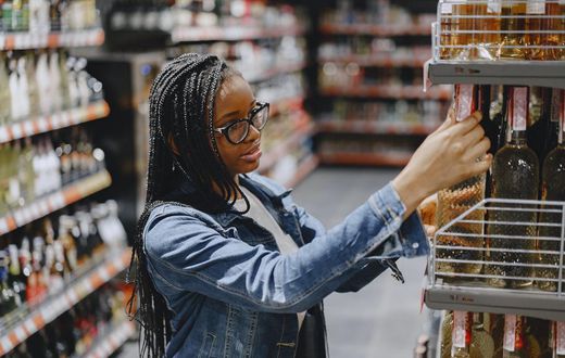 Woman shopping for wine in grocery store [Photo: Gustavo Fring]