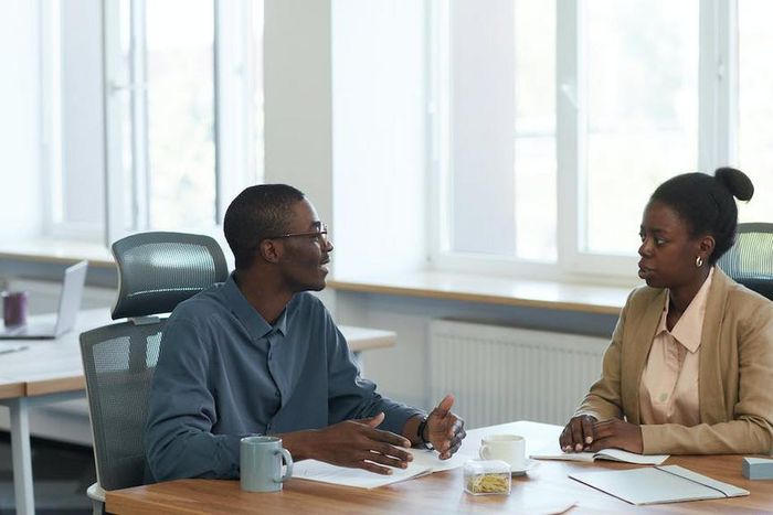 Man and woman having a conversation at the office [Image Credit: Edmond Dantès]
