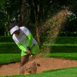 Golfer taking a shot from a sand trap