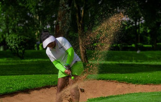 Golfer taking a shot from a sand trap