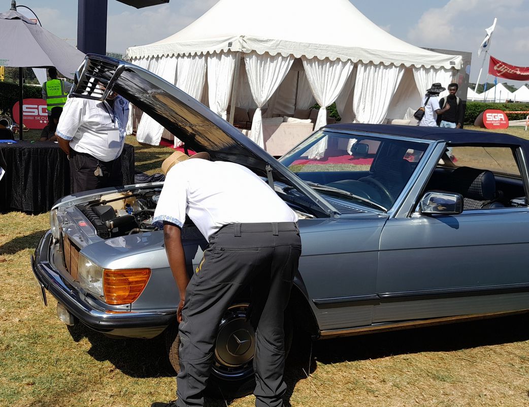 Judges at the Concours d'Elegance inspect a vehicle's engine, checking the condition, cleanliness and wiring